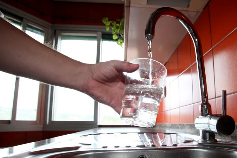 imagen de un grifo de agua de una cocina llenando un vaso