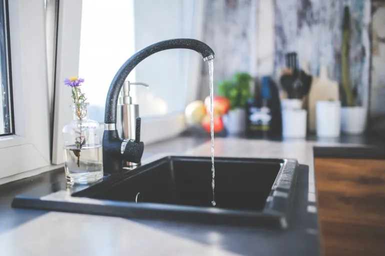 imagen de un grifo de agua abierto en una cocina