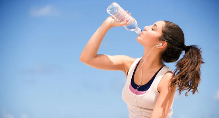 imagen de una joven bebiendo agua e hidratándose