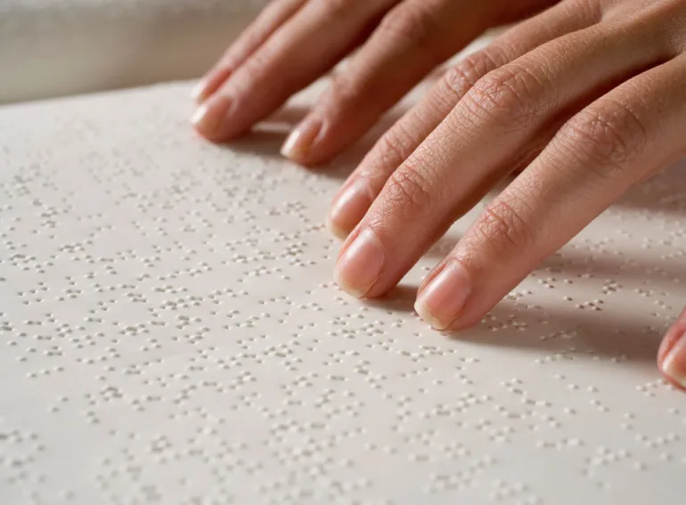 imagen de persona leyendo un libro en braille