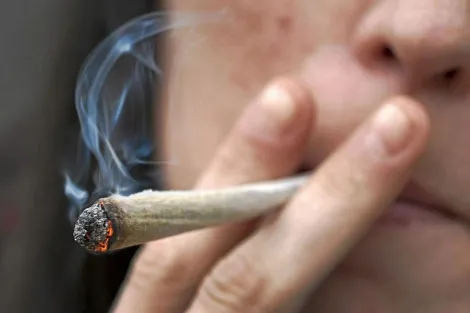 imagen de joven fumando un porro de marihuana