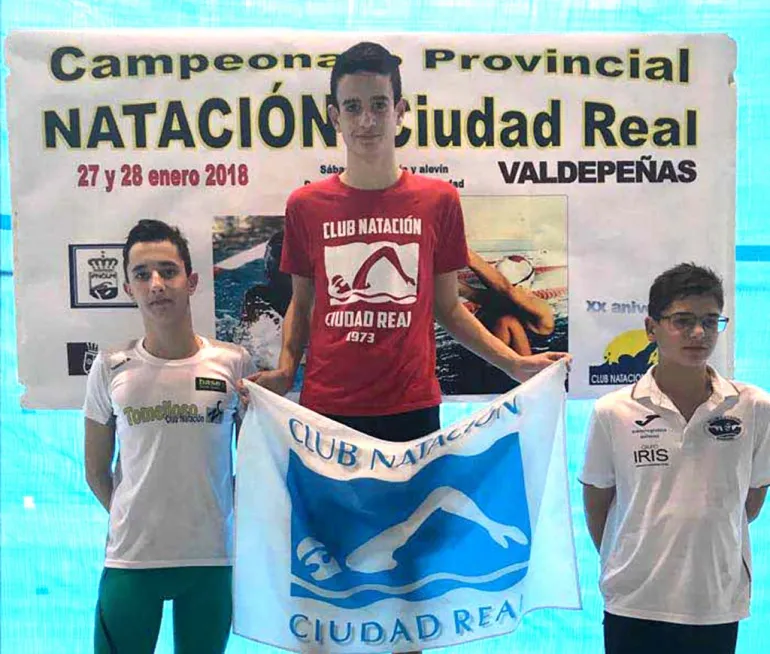 imagen de Álvaro García Gómez en lo alto del podio junto con otros dos nadadores, febrero 2018