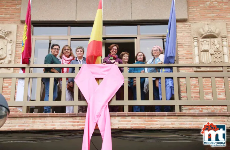 imagen de autoridades y asociación en el balcón del Ayuntamiento y el lazo rosa, octubre 2017