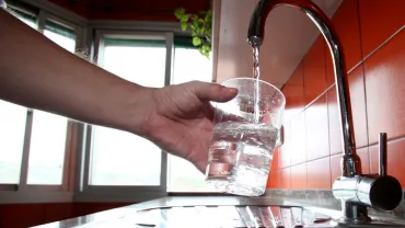 imagen de un grifo de agua mientras se llena un vaso de cristal