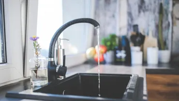 imagen de un grifo de agua abierto en una cocina