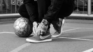 evento imagen de joven atándose unas deportivas y balón de fútbol