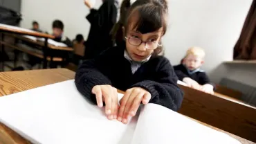 imagen de alumnado consultando libros en braille