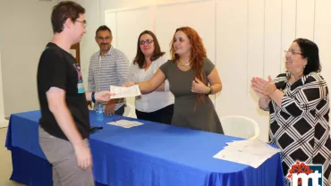 imagen de un alumno del curso de Iniciación a Adobe Photoshop recogiendo su diploma de manos de los responsables municipales, octubre 2015