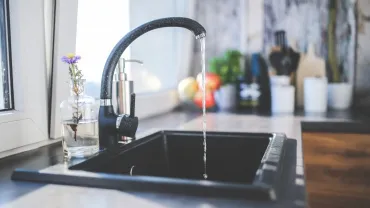 imagen de una cocina y un grifo de agua abierto