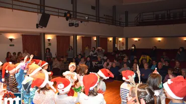 imagen de personas usuarias del SED y alumnado del colegio El Pradillo cantando villancicos, diciembre 2019