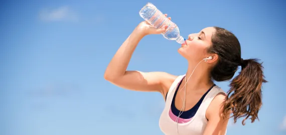 imagen de una joven bebiendo agua e hidratándose