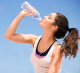imagen de una joven bebiendo agua e hidratándose